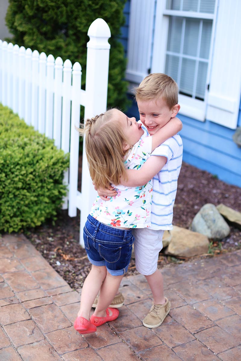 Sibling hugs! Boston holds Savy and lifts her feet of the ground as Savy sticks out her tongue.