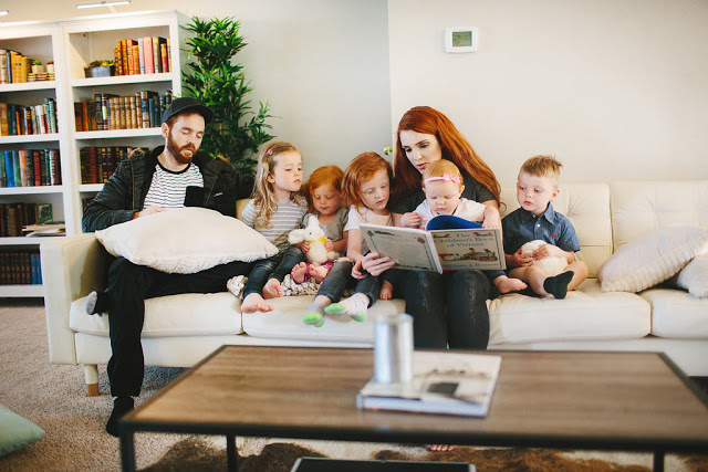 Emma from The Freckled Fox reads to her children with her husband.